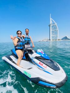 Jet ski riders gliding through the calm waters of Dubai, with Dubai skyline