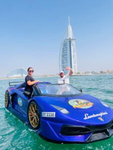 Thrill-seekers racing across the sparkling waters of Dubai in a JetCar, with iconic landmarks